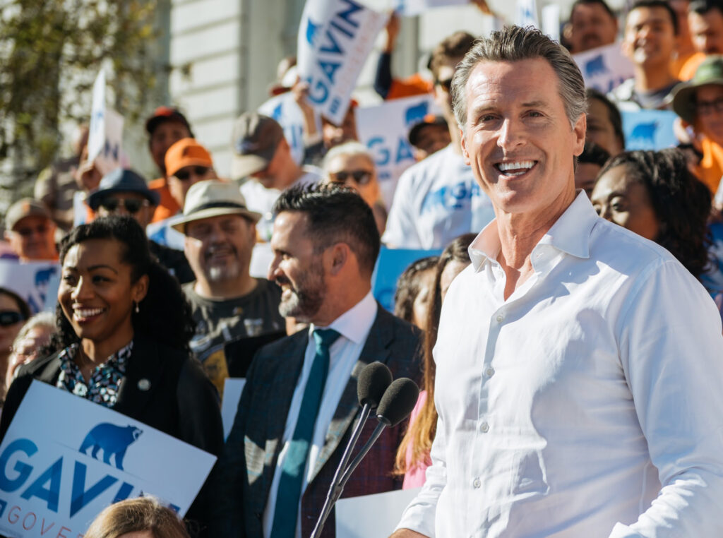 Photo of Governor Gavin Newsom with supporters at a campaign rally.
